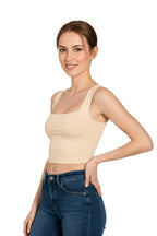 Side view of a woman wearing a beige square neck crop top paired with high-waisted blue jeans.