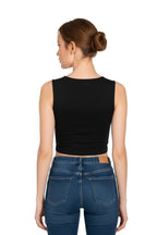 Back view of a woman wearing a black square neck crop top paired with high-waisted blue jeans.